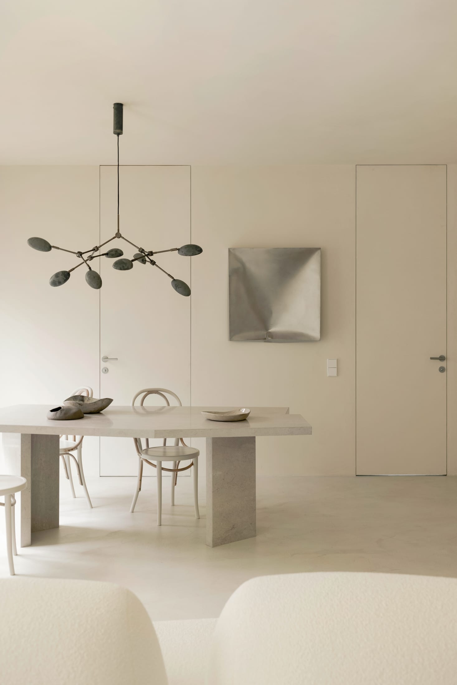 A large slim-framed mirror reflecting the window and light in the living area.