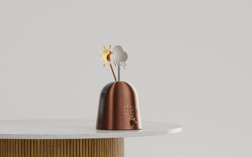 A metallic Skymill device with sun and rain icons on a white table.