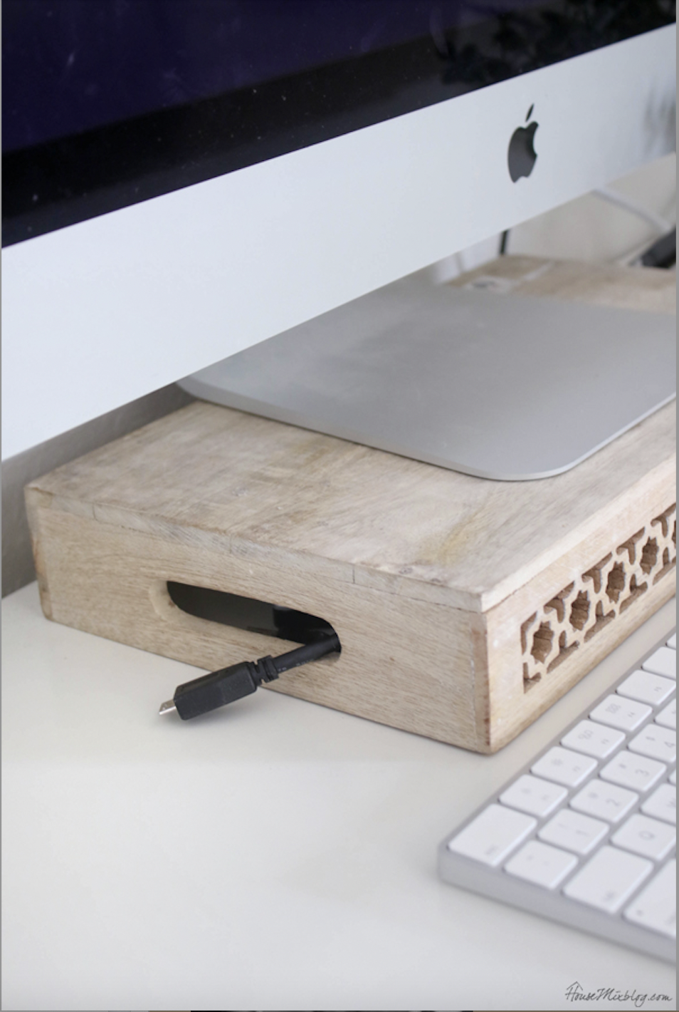 Close-up of power cords and chargers neatly tucked under a wooden crate handle.
