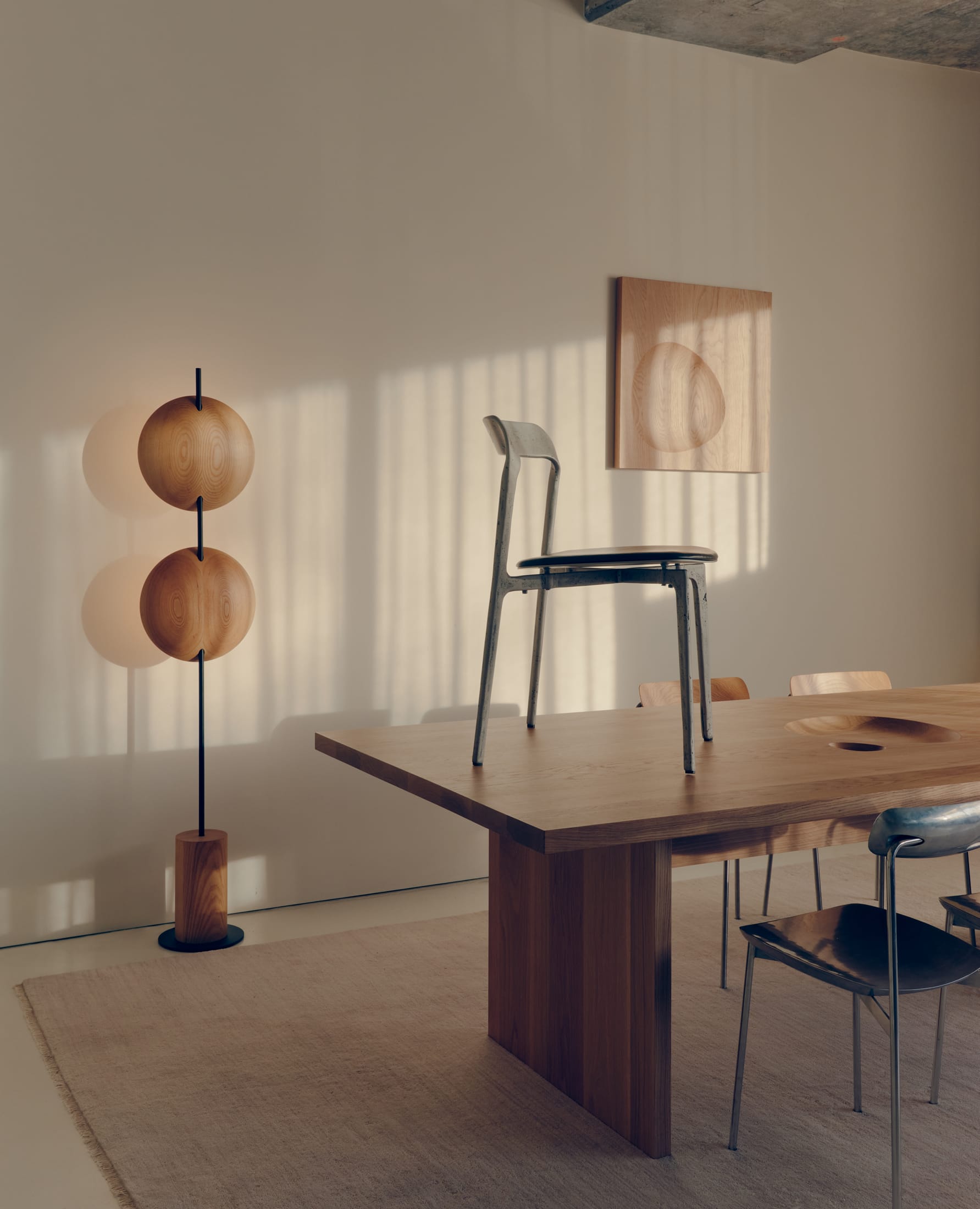 A minimalist chair design displayed in a gallery setting with soft lighting.