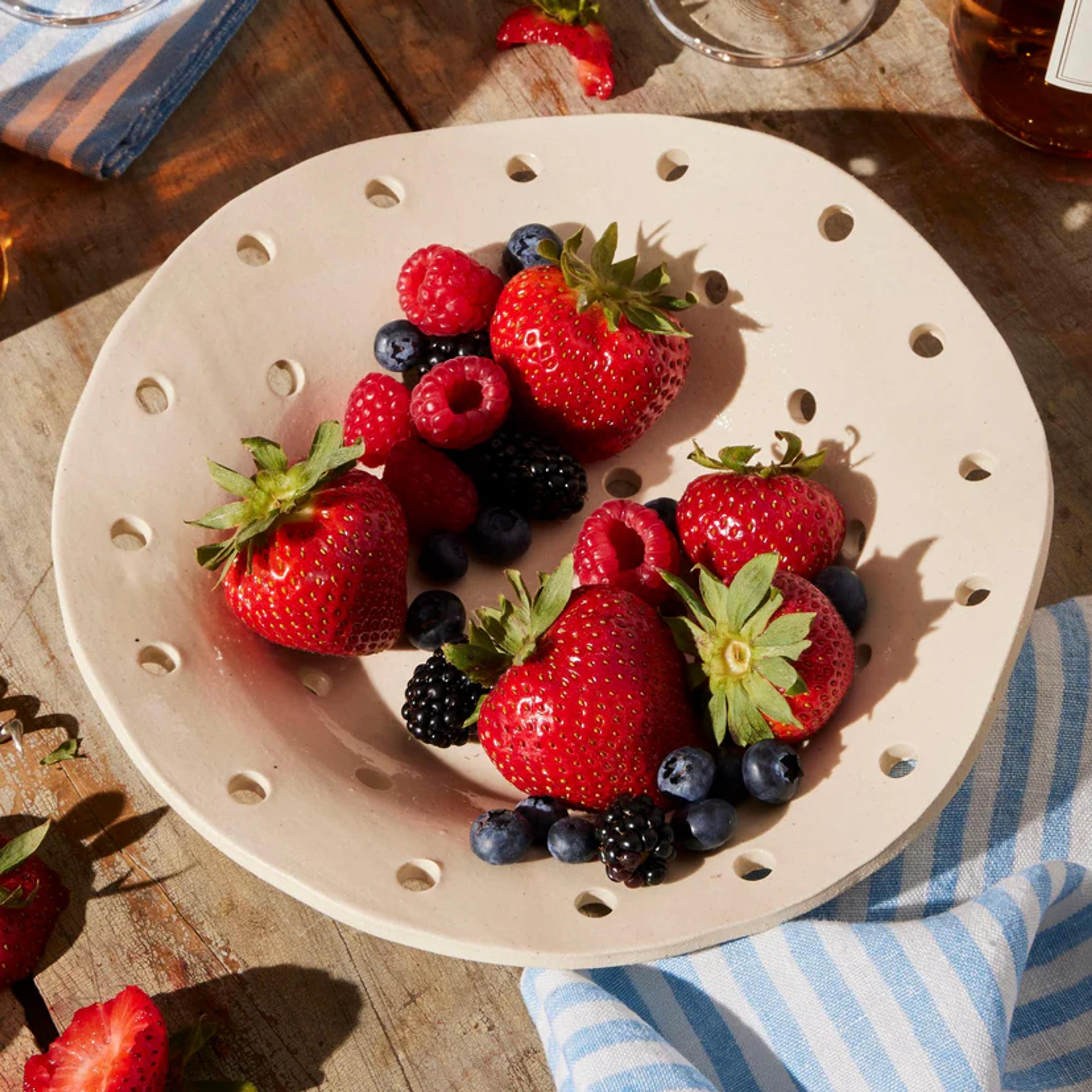 A modern SIN ceramic berry bowl for washing and serving fresh fruit.