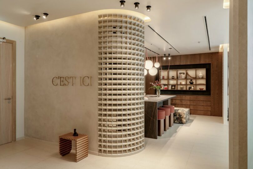 A curved 3D-printed lattice wall partition inside the studio.