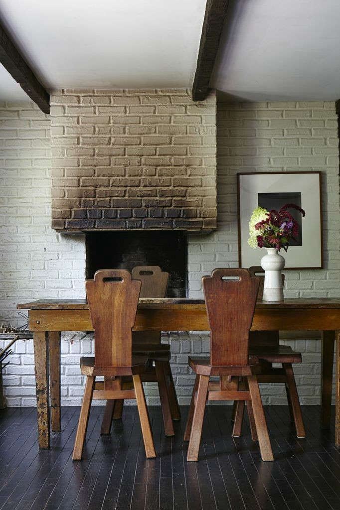 A pair of weathered, antique peasant chairs in a lived-in residential setting.