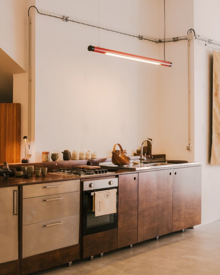 A 6-meter-long kitchen island made of plywood with a vintage stainless steel sink.