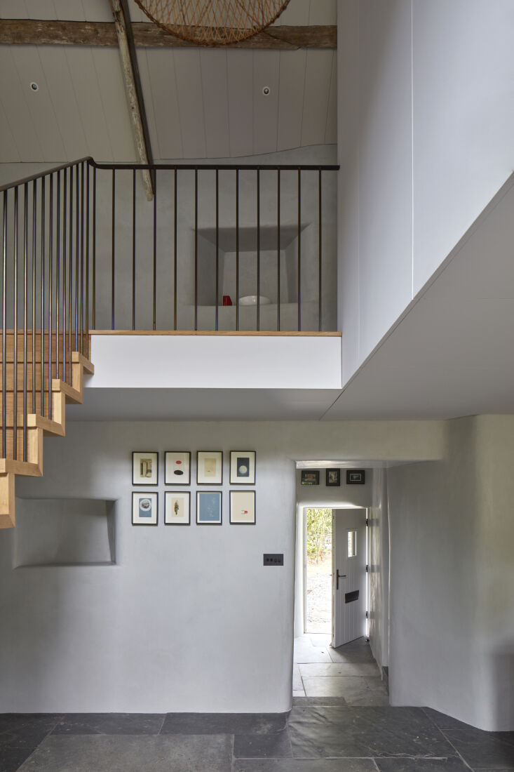 A serene interior corner showing a palette of plaster, slate, oak, and painted wood paneling.
