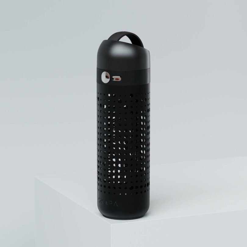 A black cylindrical reusable water bottle with a perforated design and a sleek metal cap.