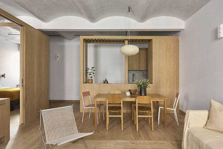 Large freestanding white oak millwork unit acting as a room divider and storage hub.
