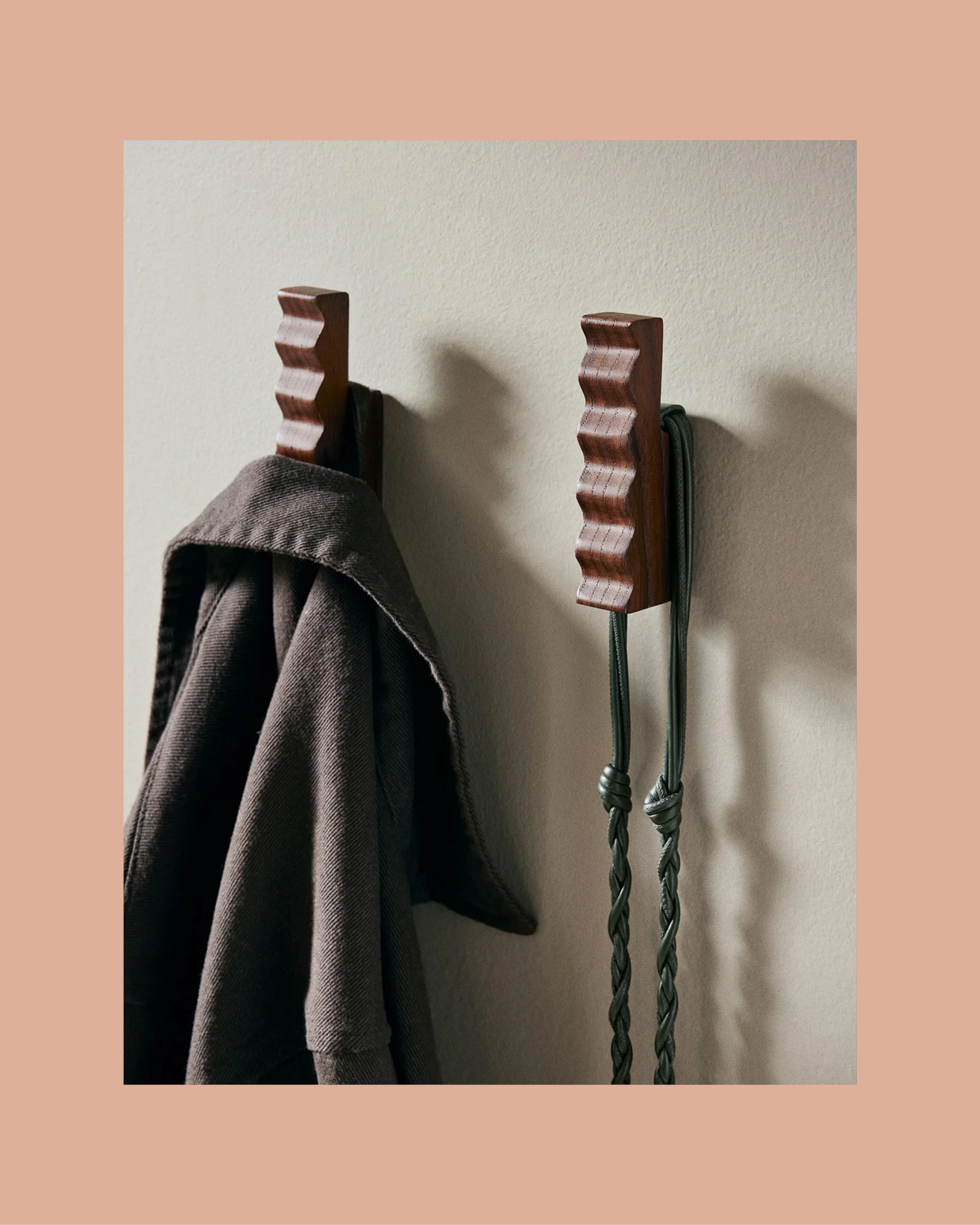Close-up of sculptural, rippled wooden cabinet pulls on a dark wood drawer.