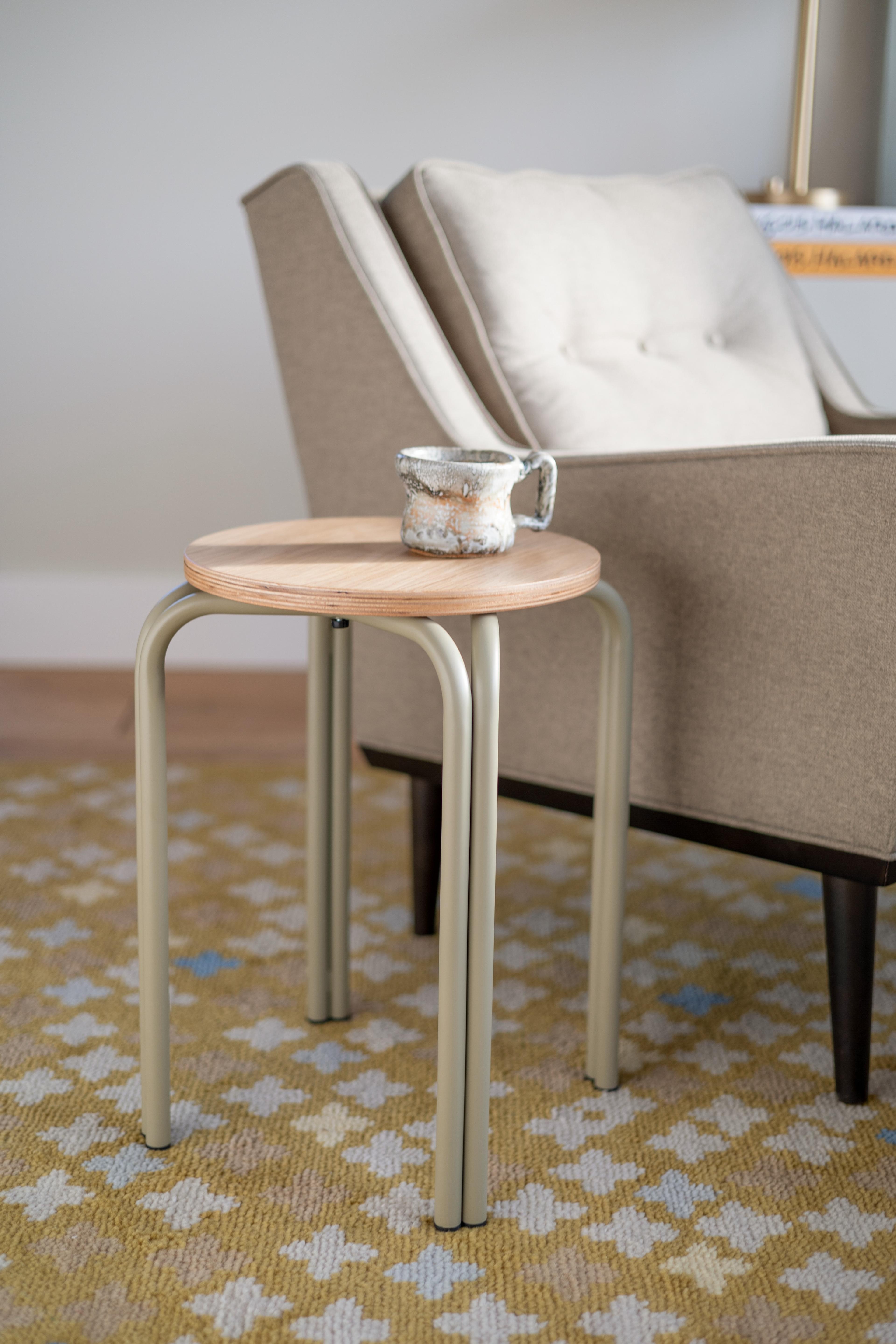 A small side table placed on a textured area rug.