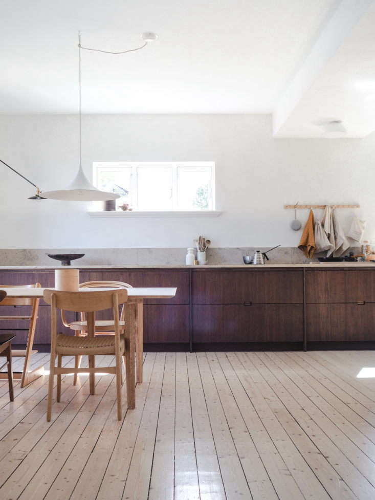Transition between pine flooring and bamboo kitchen cabinets in a modern home.