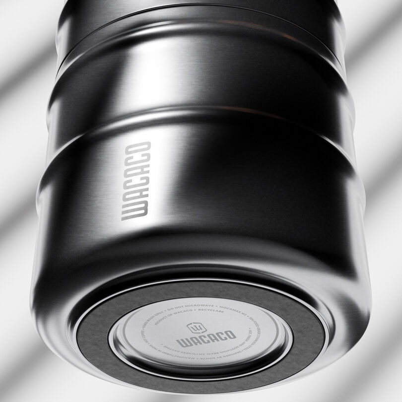 Close-up view of a metallic Wacaco travel mug showing brand detailing and textured surface.