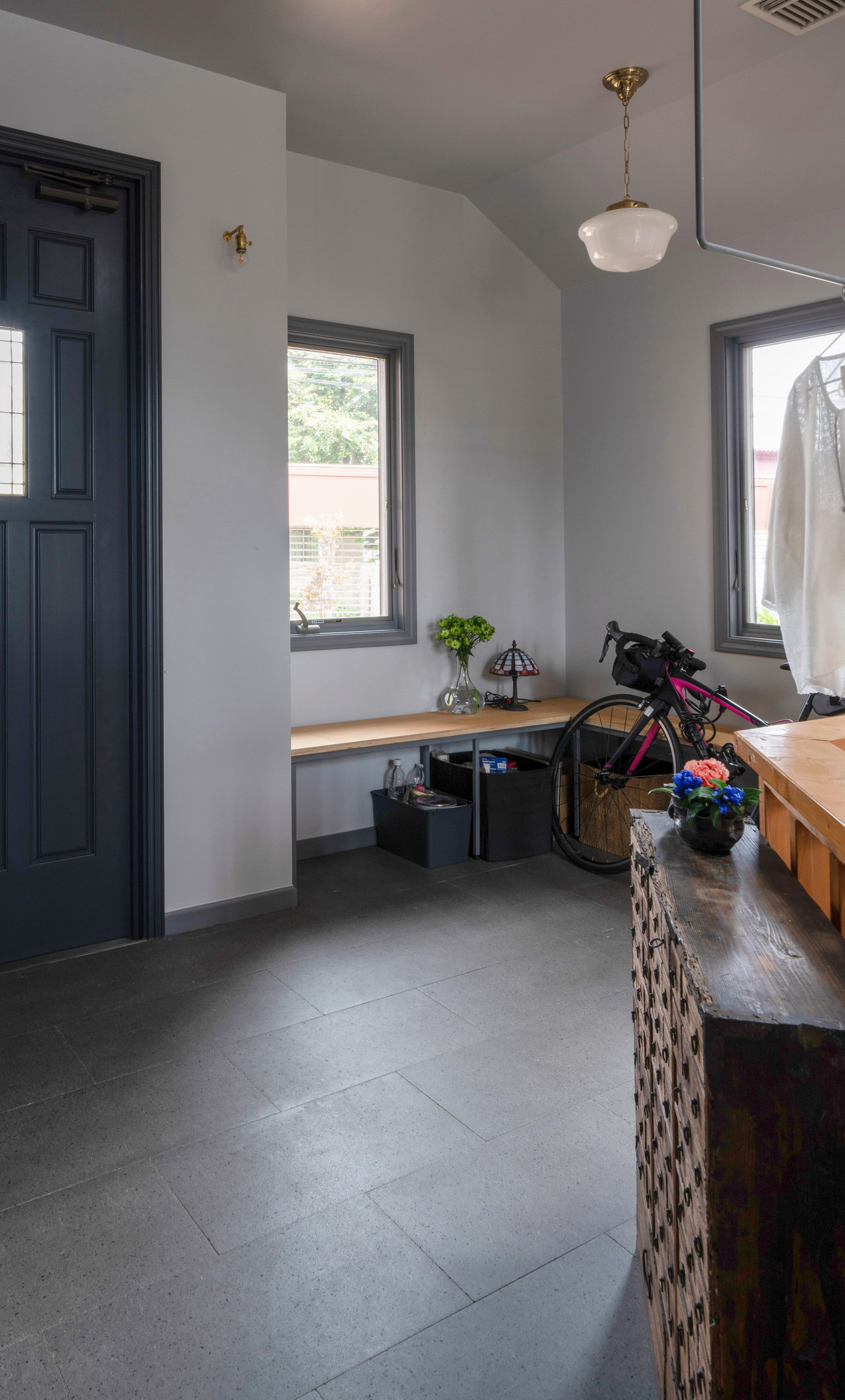 A minimalist residential living room with built-in steel-framed benches and large windows.