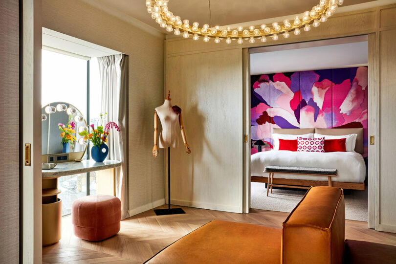 A BoTree Hotel suite with a fashion mannequin, round chandelier, and city view.