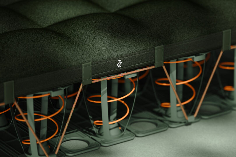A technical cross-section of the mattress showing the orange coil springs sandwiched between green support layers.