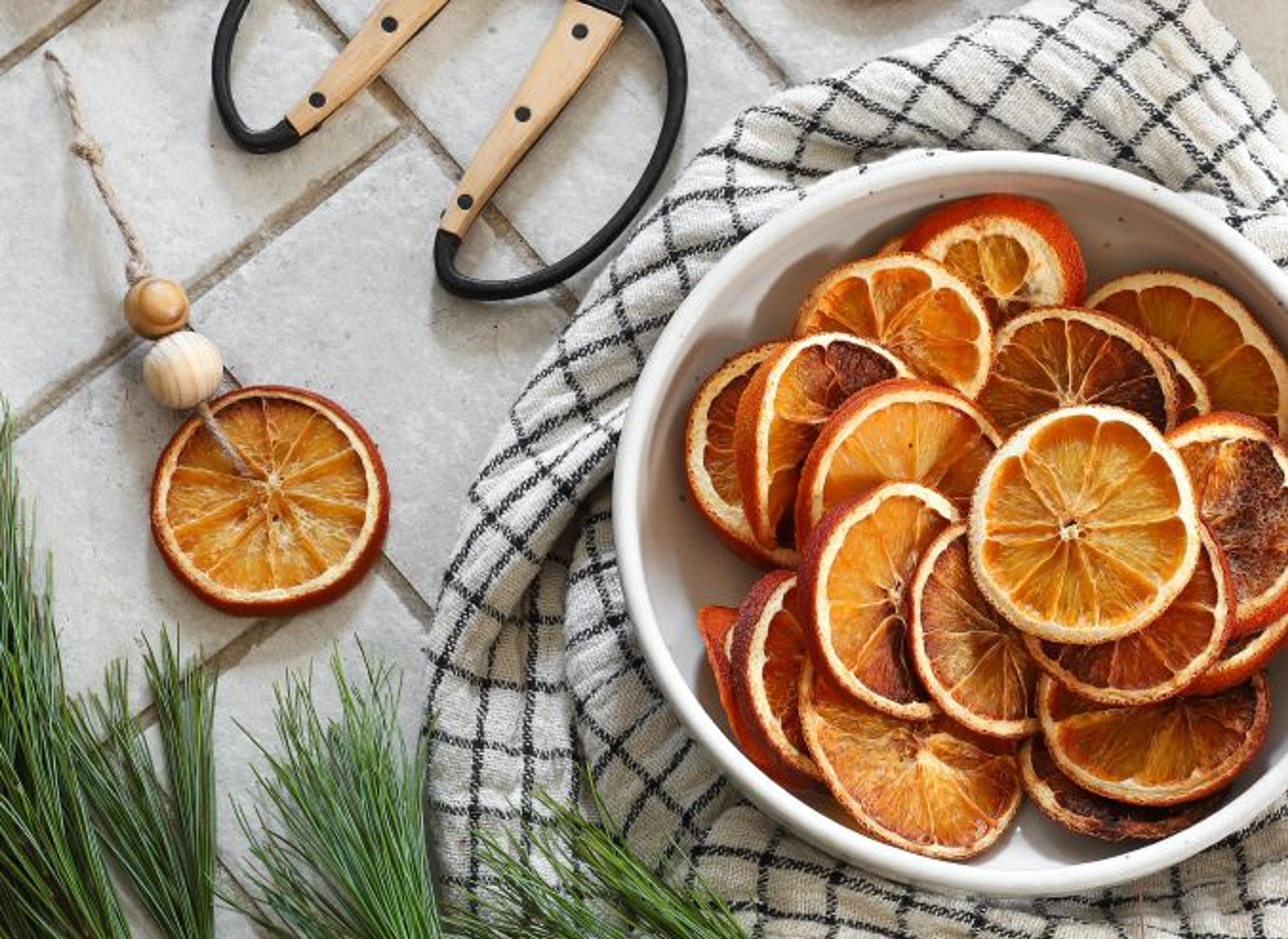 Close-up of dried orange slices and natural holiday decor elements on a table.