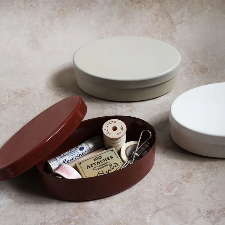 An enamel bento box used to store washi tape, pens, and sewing notions.