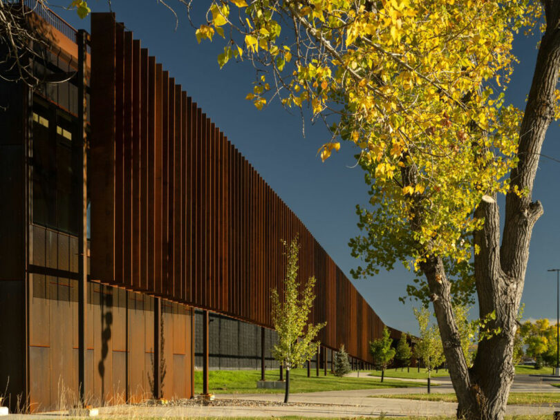 Modern industrial building with a rusted metal exterior and vertical panels during autumn in Wyoming.
