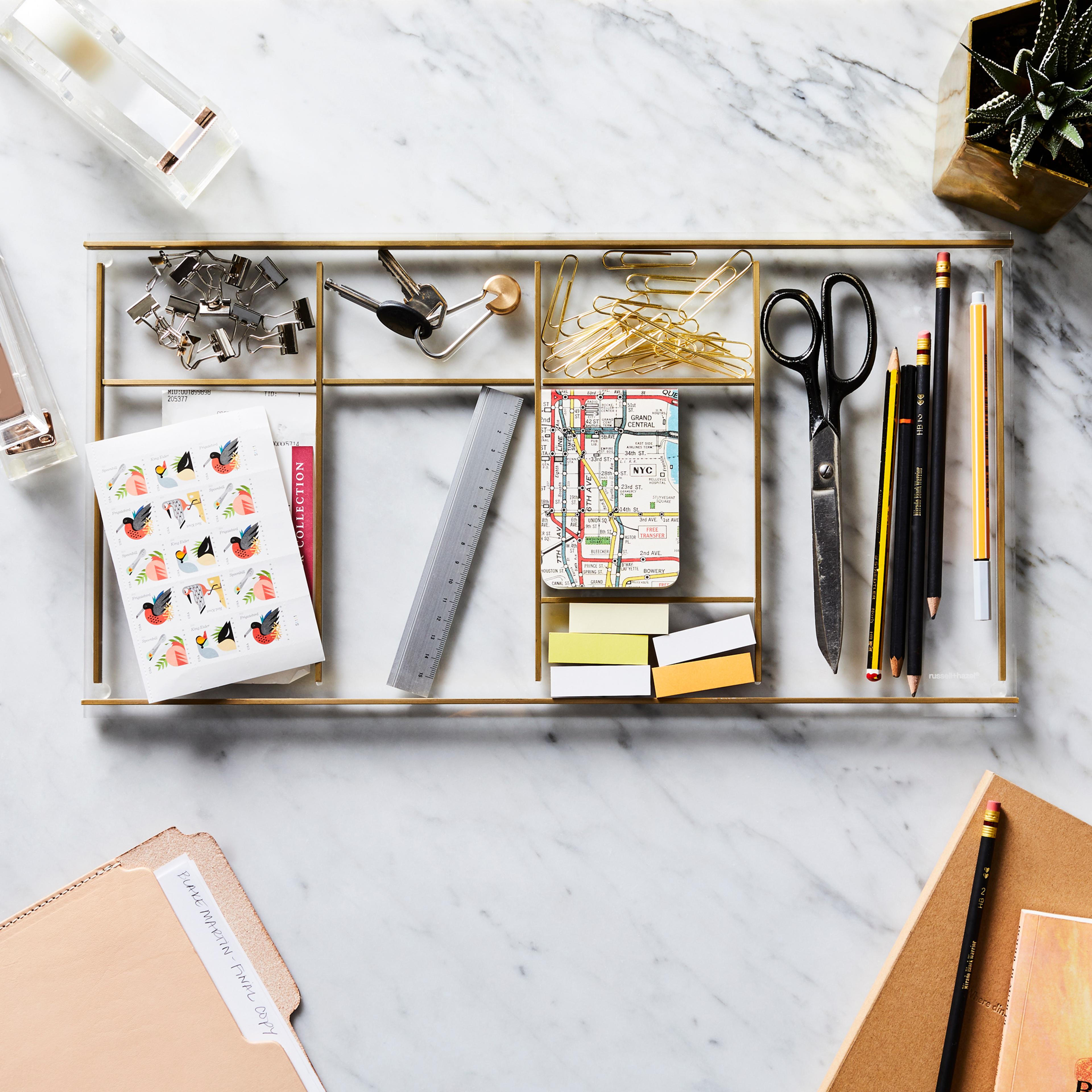 Close-up of organized desk supplies including a stapler, tape dispenser, and scissors.