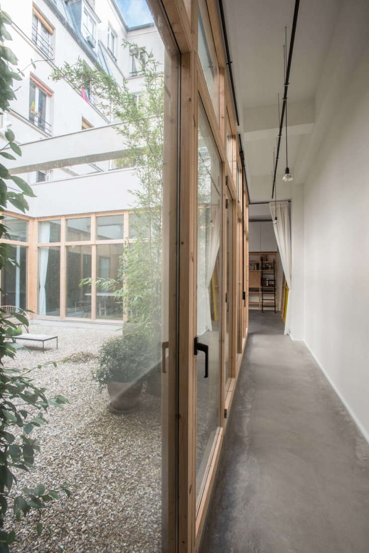 A wide shot of a 387-square-foot central courtyard with original industrial support beams overhead.