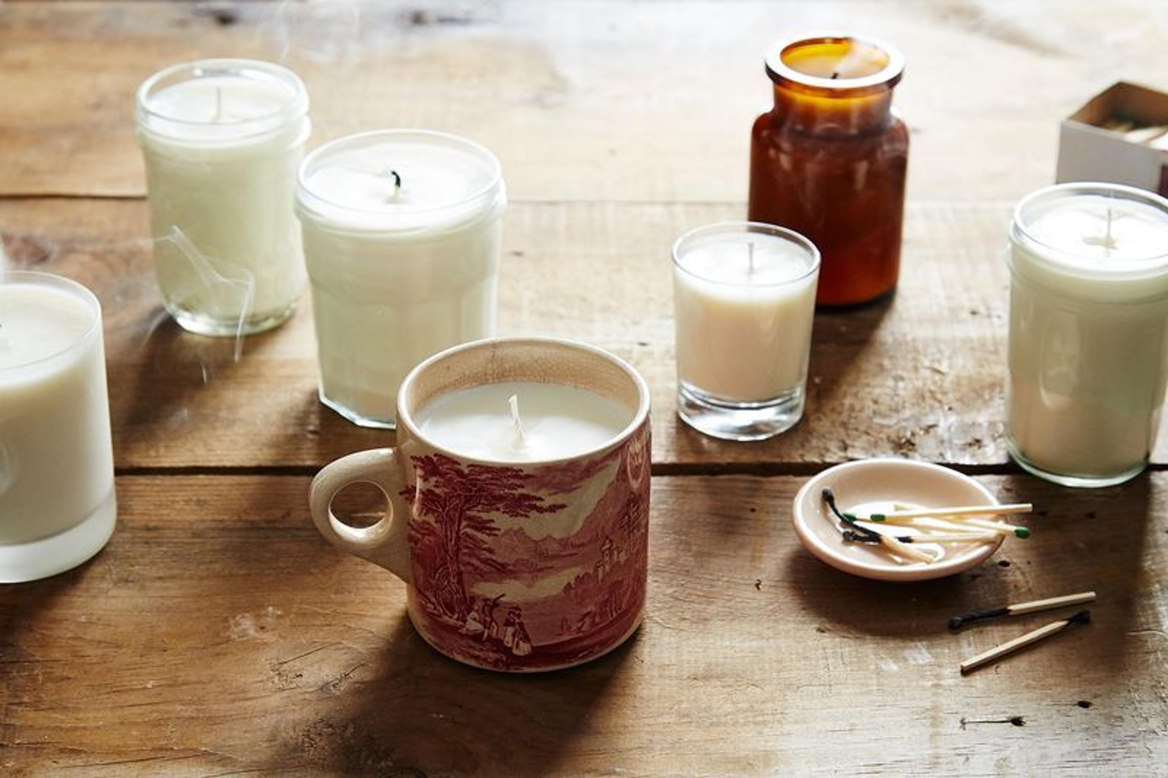 A handmade holiday candle DIY project with festive garnishes.