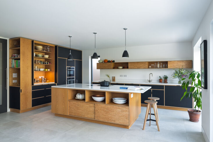 Bespoke kitchen cabinetry with cork-veneered fronts and a dedicated niche for large serving bowls.