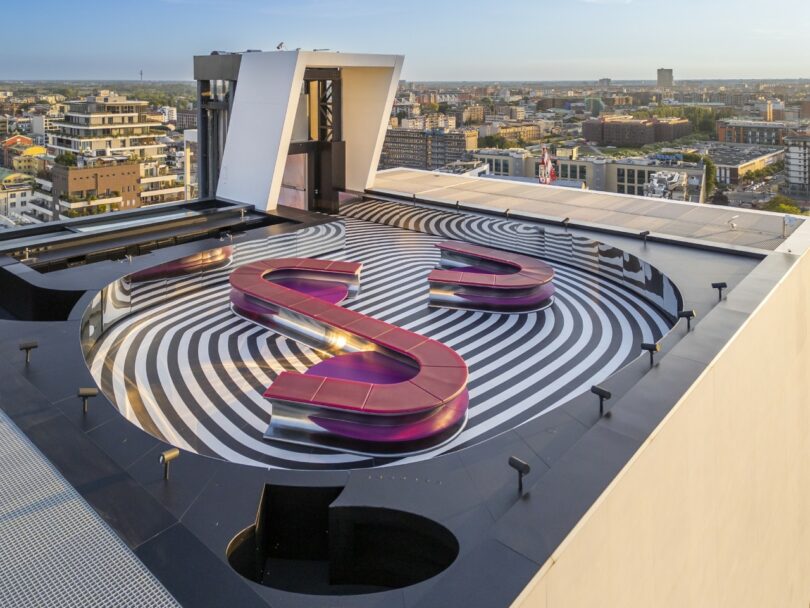 Winding pink modular benches creating organic shapes on a rooftop.