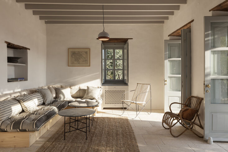 A custom sofa base made of natural pine wood topped with striped cushions.