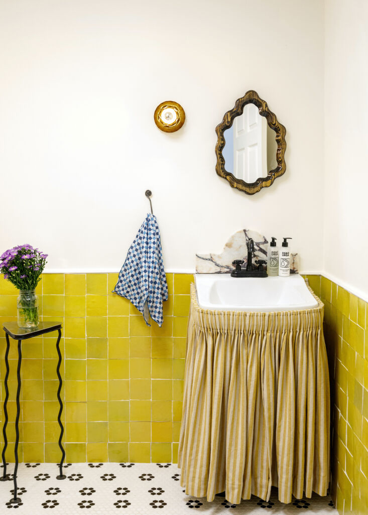A chartreuse pleated sink skirt matching yellow zellige wall tiles.