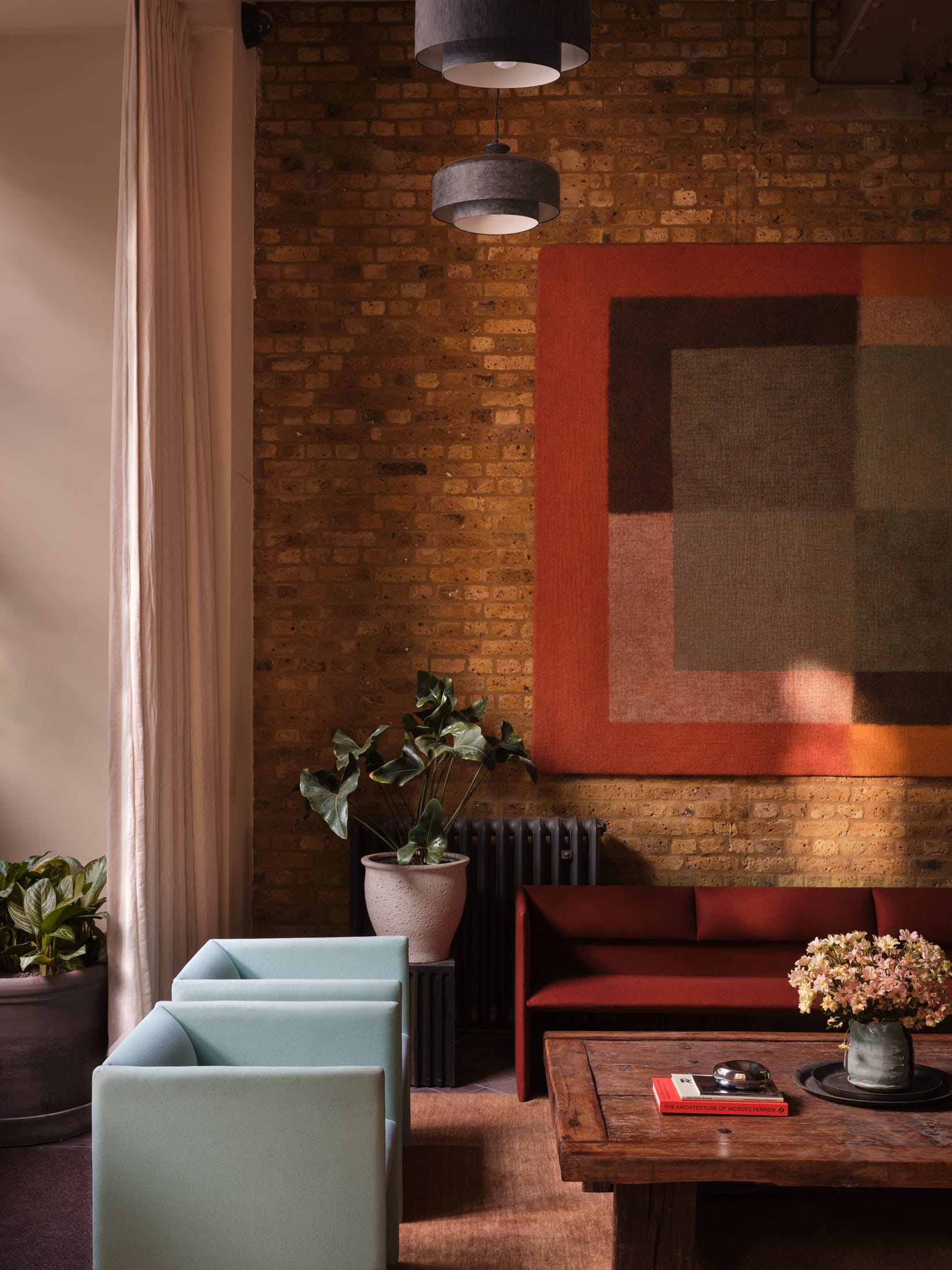 A view of the internal courtyard with large potted plants and natural light filtering from above.