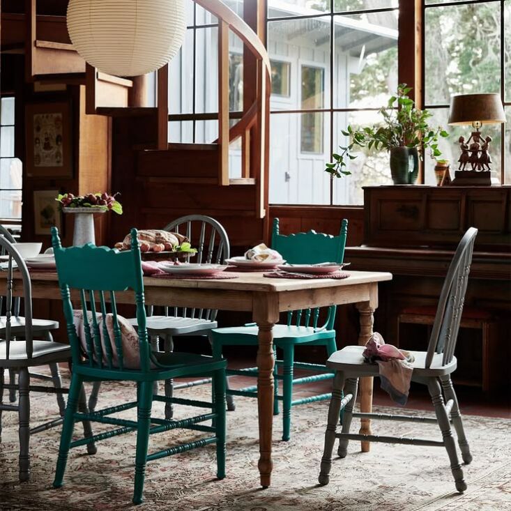Green and gray solid wood dining chairs with a classic spindle design.