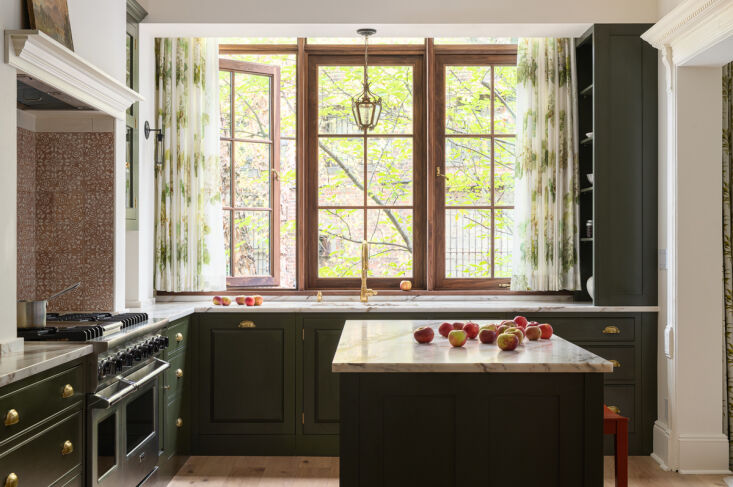 A large black walnut-framed bay window overlooking a backyard garden.