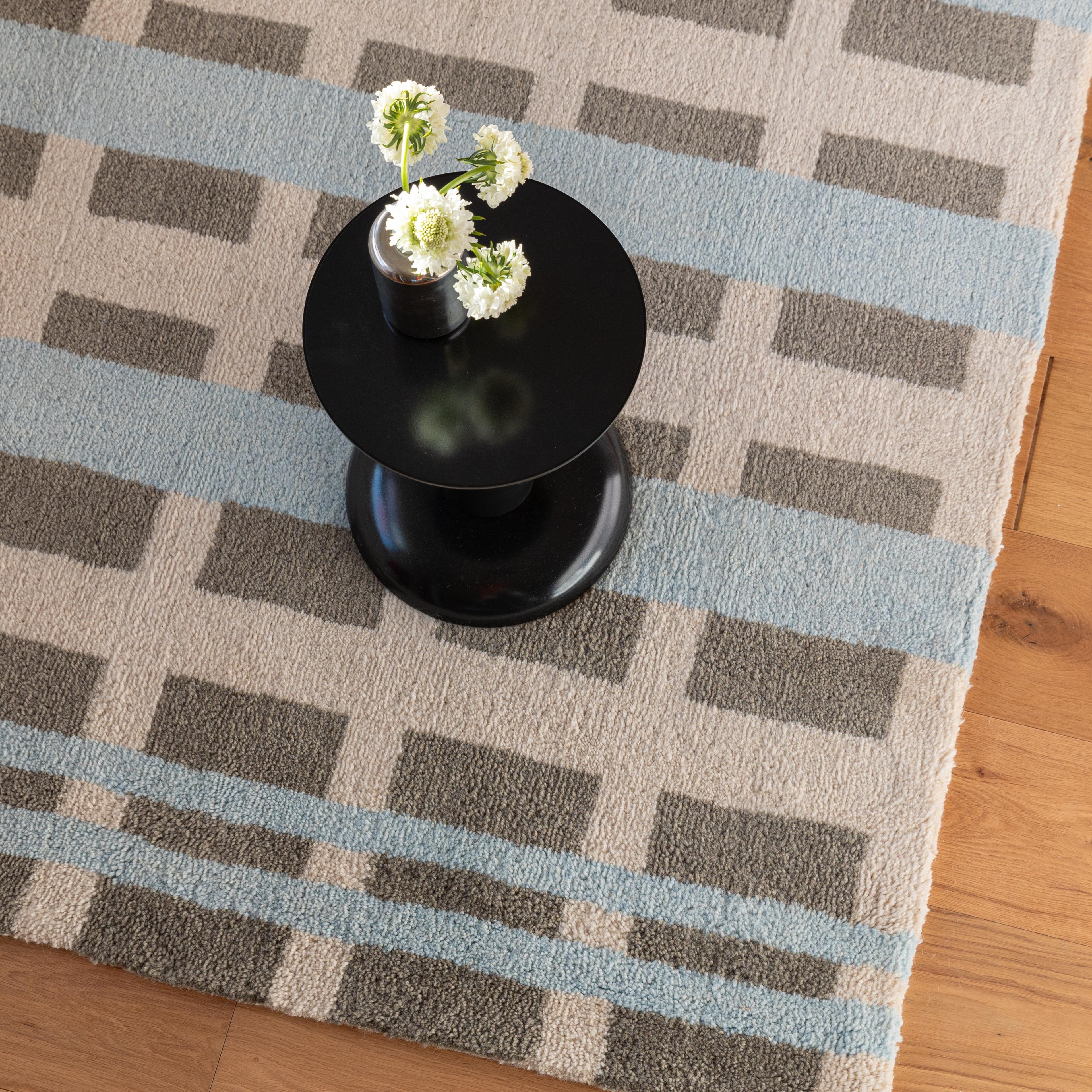Overhead view of a patterned blue and buttercream rug.