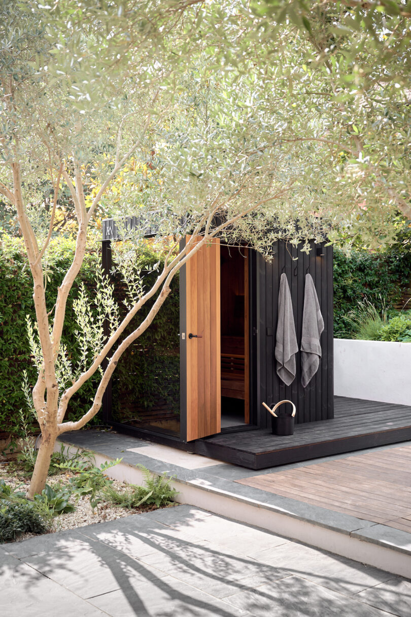 The open doors of a garden sauna with towels ready for use.