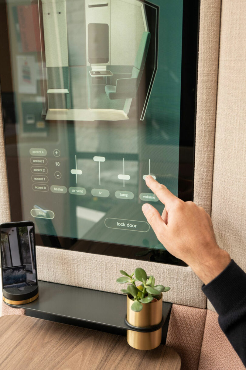 A close-up of a person's finger adjusting a volume slider on a Kabin digital touchscreen interface.