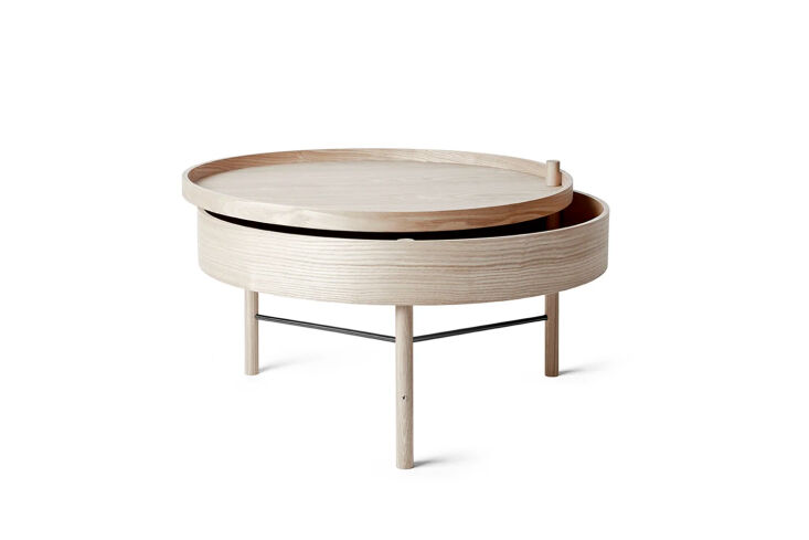 An oak side table with a lid that rotates open around one of its legs.