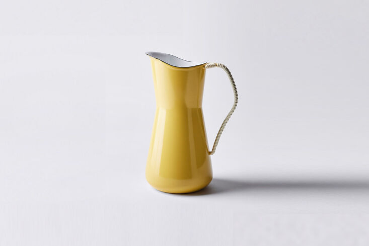 A yellow Dansk Købenstyle Water Pitcher featuring a handwoven handle and black rim.