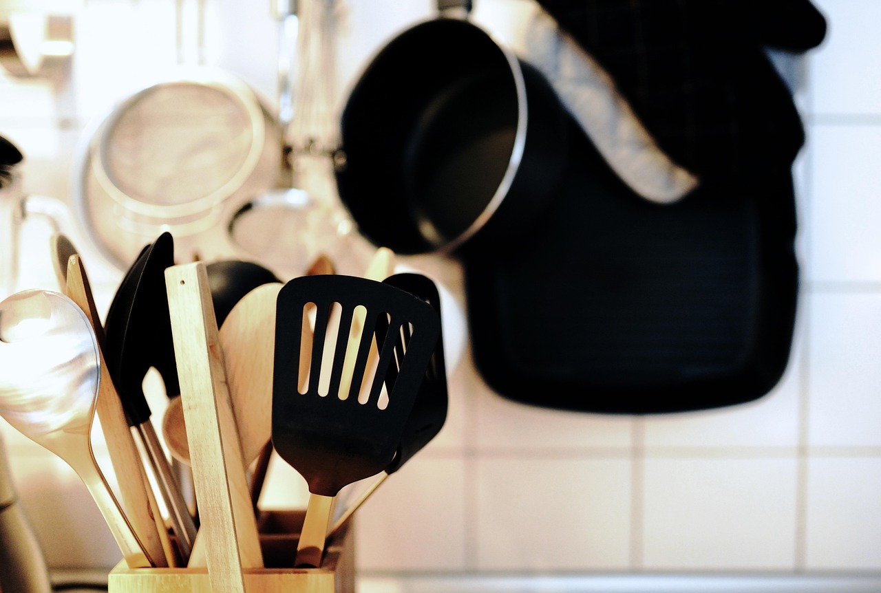 A wooden spoon stirring a steaming pot of soup on a stove
