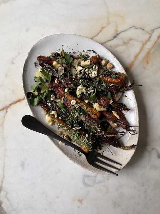 Uniformly cut root vegetables roasted to a deep golden brown on a parchment-lined baking sheet.