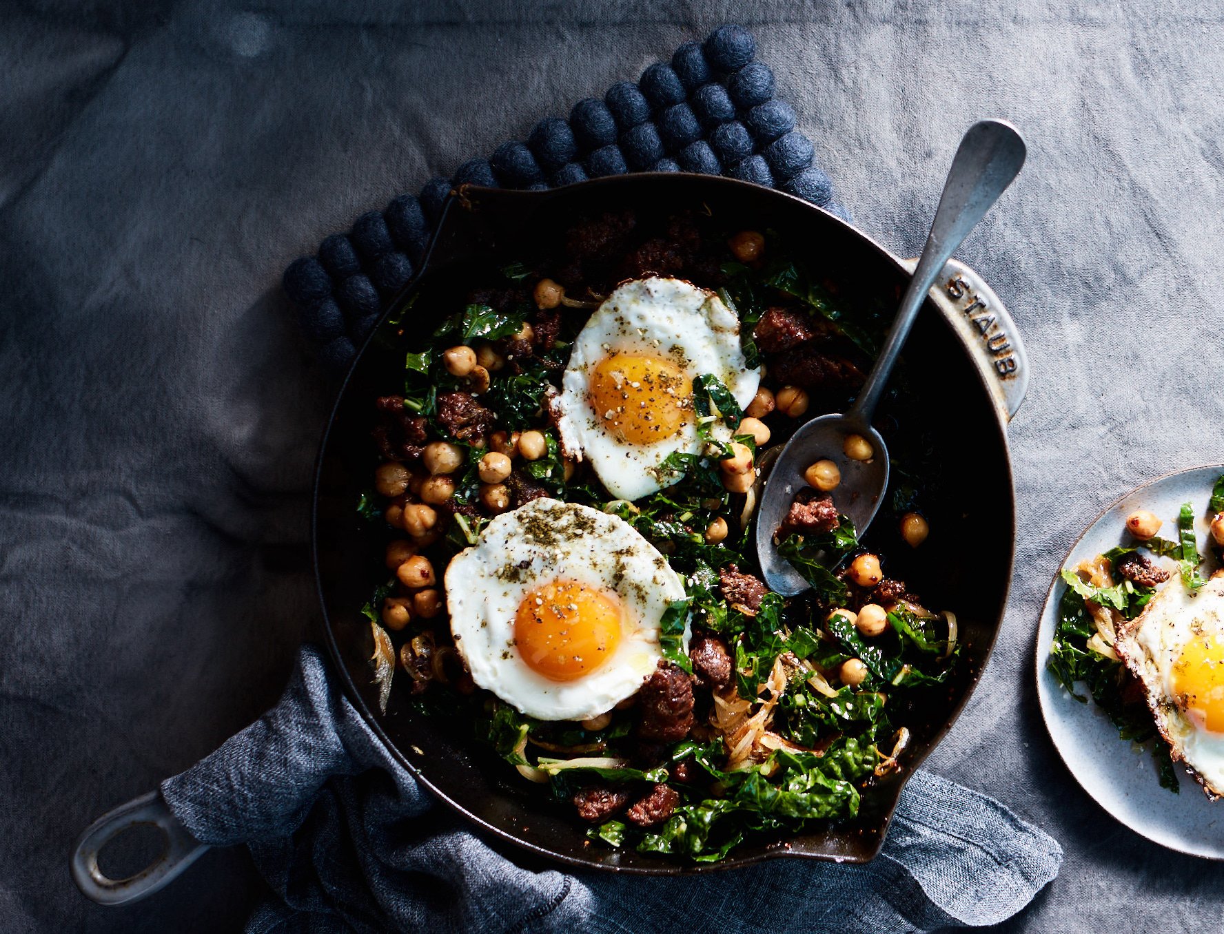 Close-up of chickpea and Merguez sausage hash with wilted greens and spices.