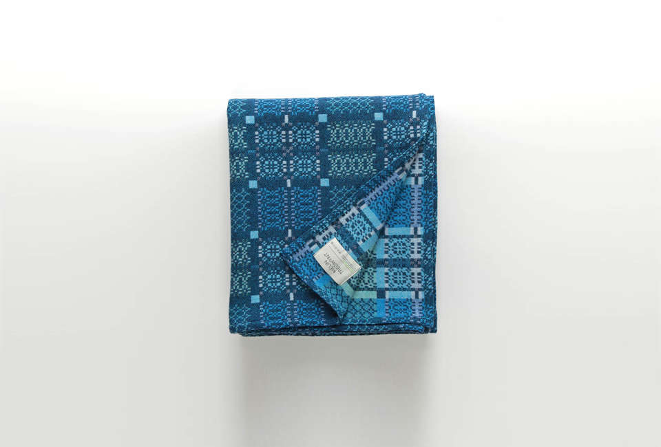 A traditional Welsh pattern wool throw in shades of blue and white.