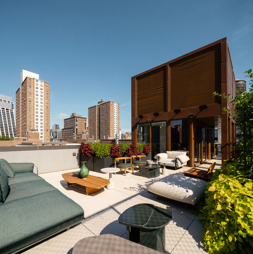 A rooftop terrace with modern furniture overlooking the New York City skyline.