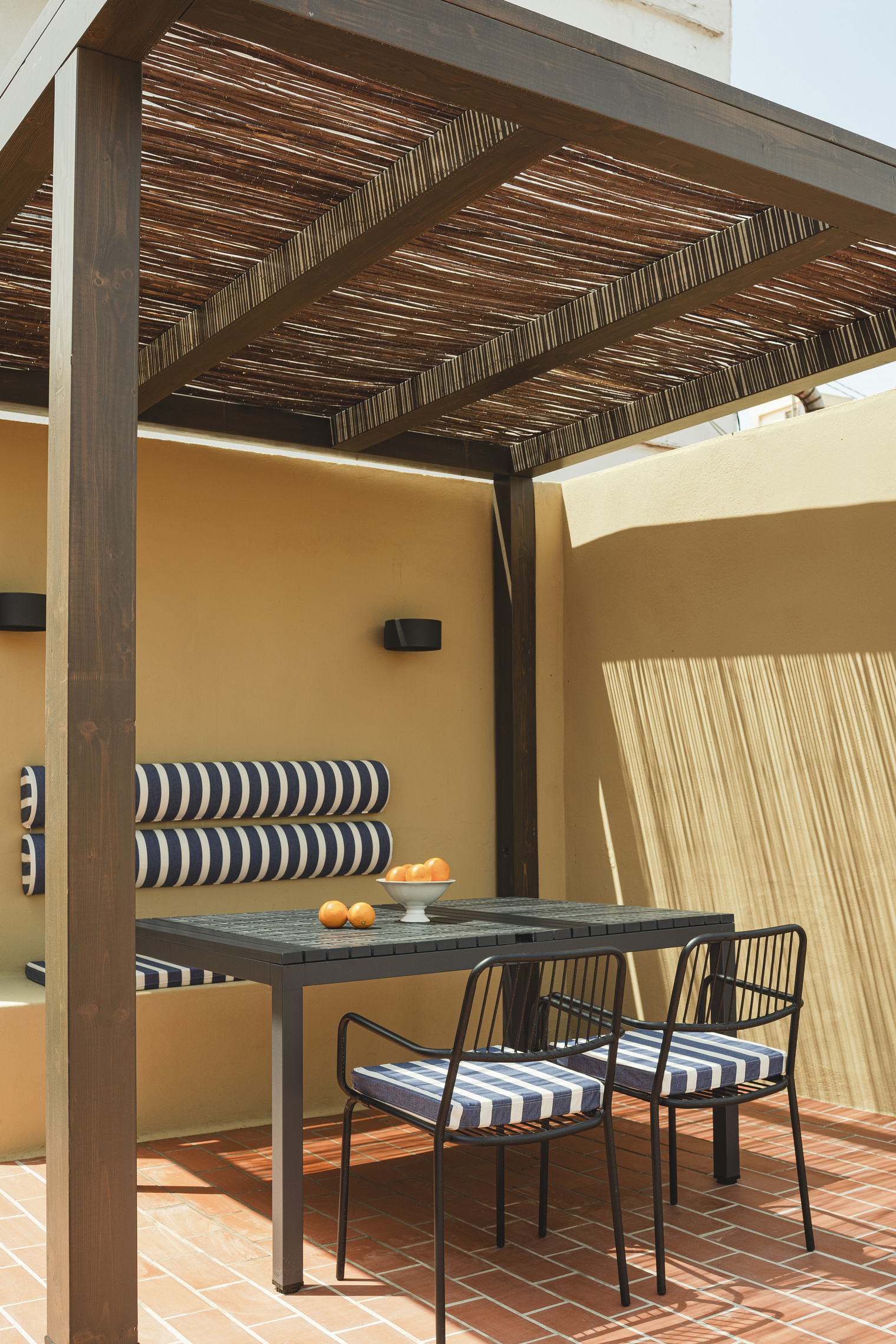 Rooftop terrace featuring blue-and-white striped tiles and traditional terracotta paving.