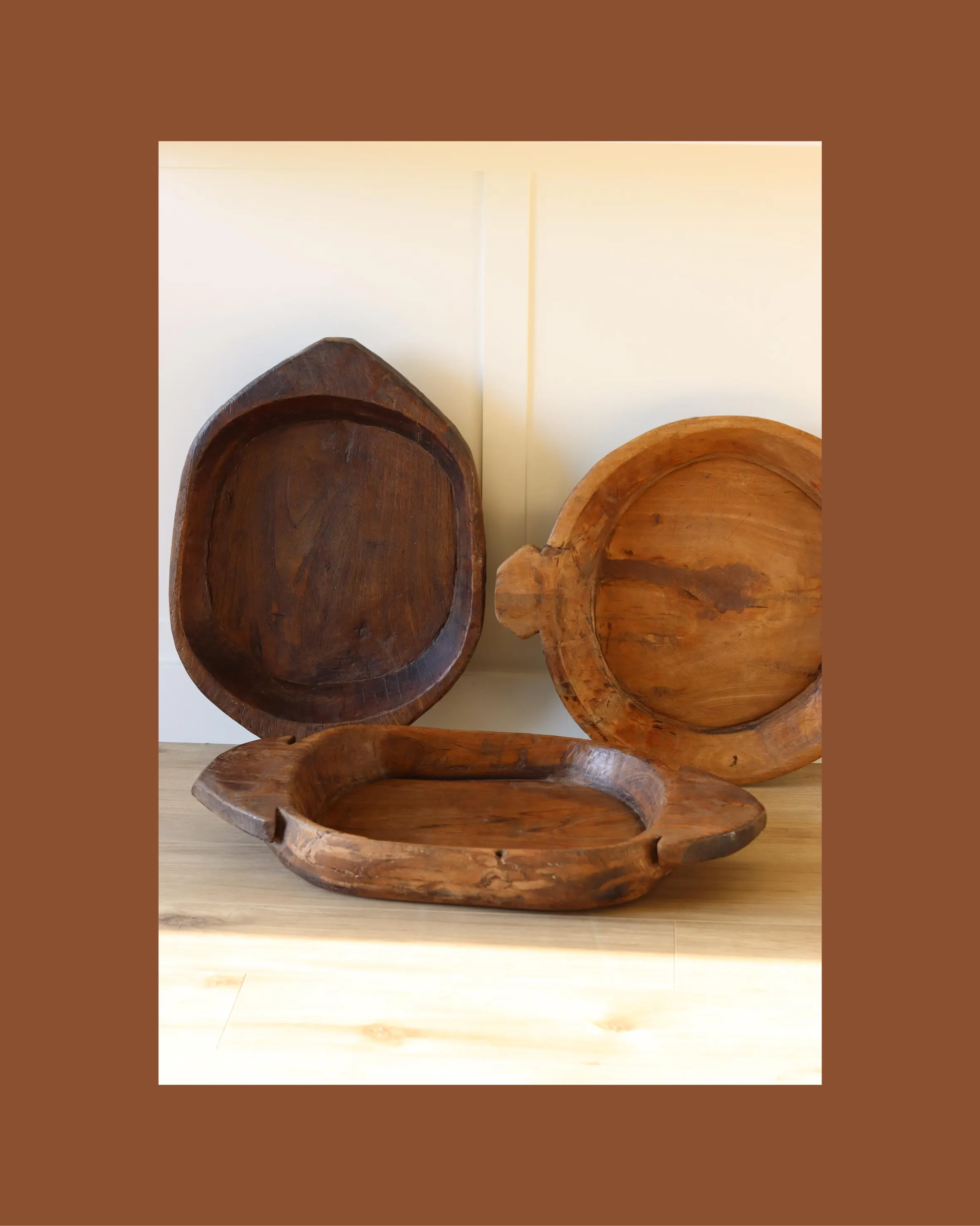 A large, rustic hand-carved wooden dough bowl used as a centerpiece.