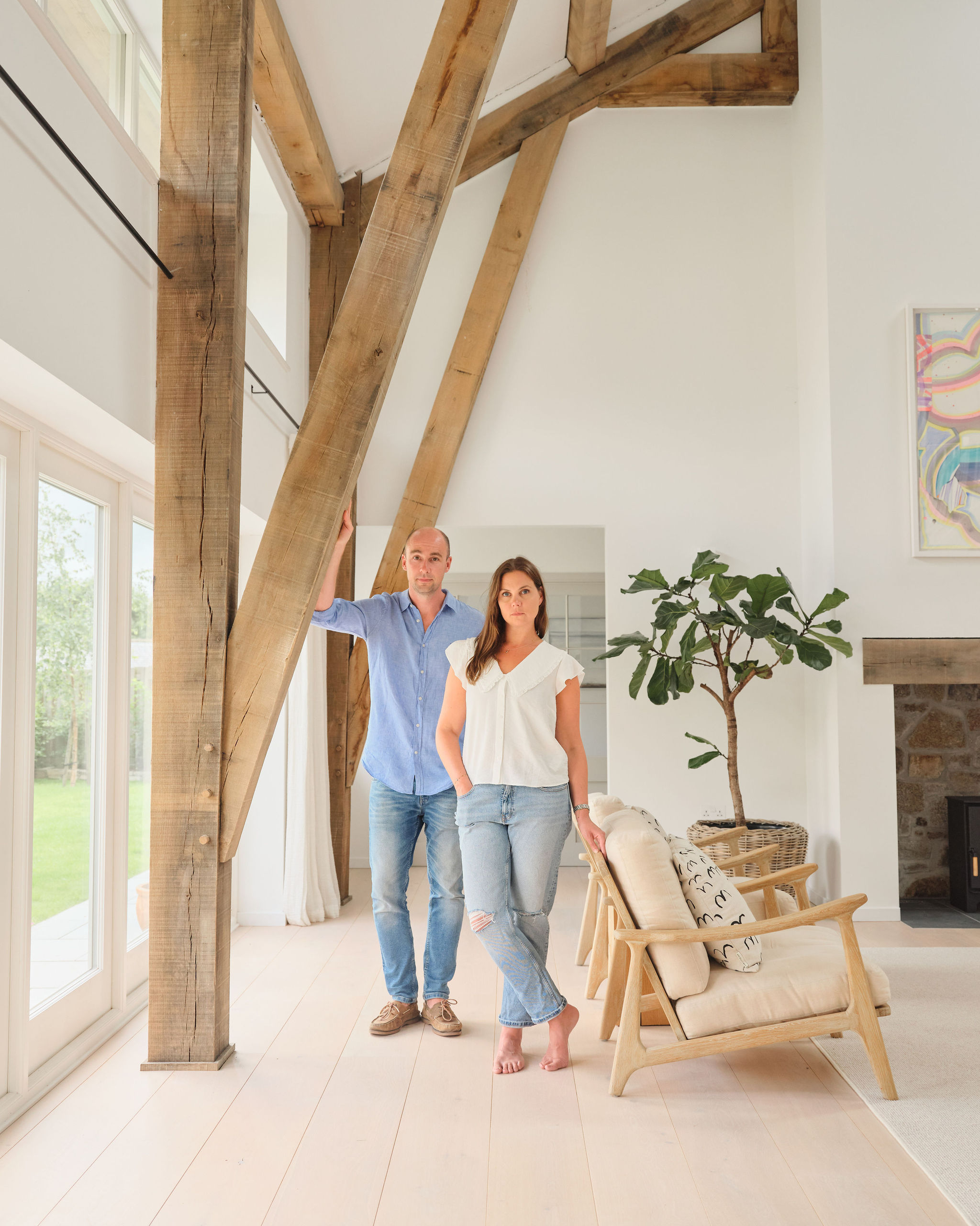 Spacious open-plan living room with white oak flooring and minimalist furniture in a modern barn.