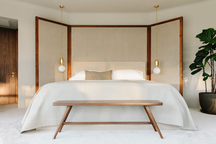 A bedroom in Beijing featuring a large custom folding screen headboard designed by Studio Ilse.