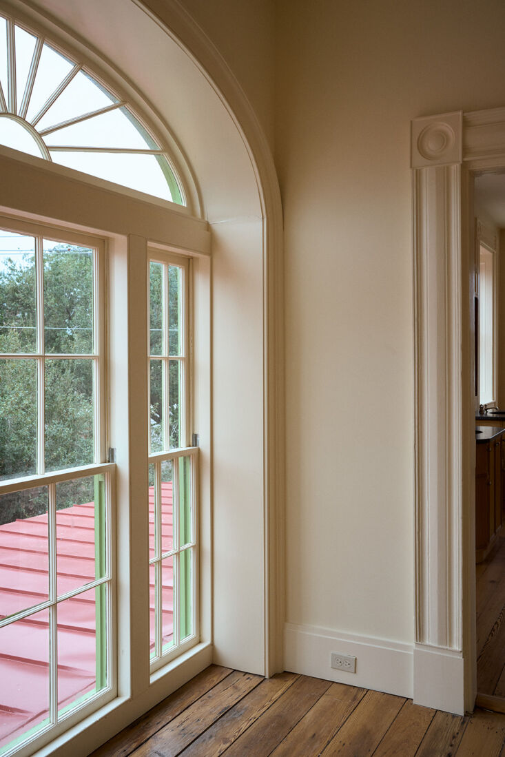A large Palladian window at the top of a staircase casting bright natural light into the interior.