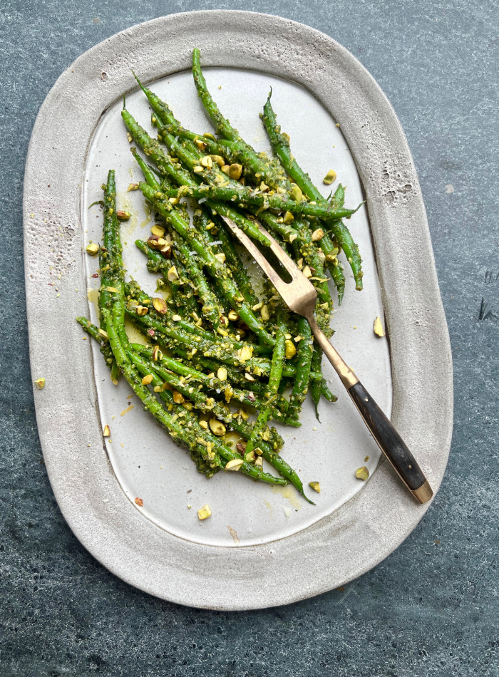 Green beans being moved from boiling water into a large bowl of ice and water.