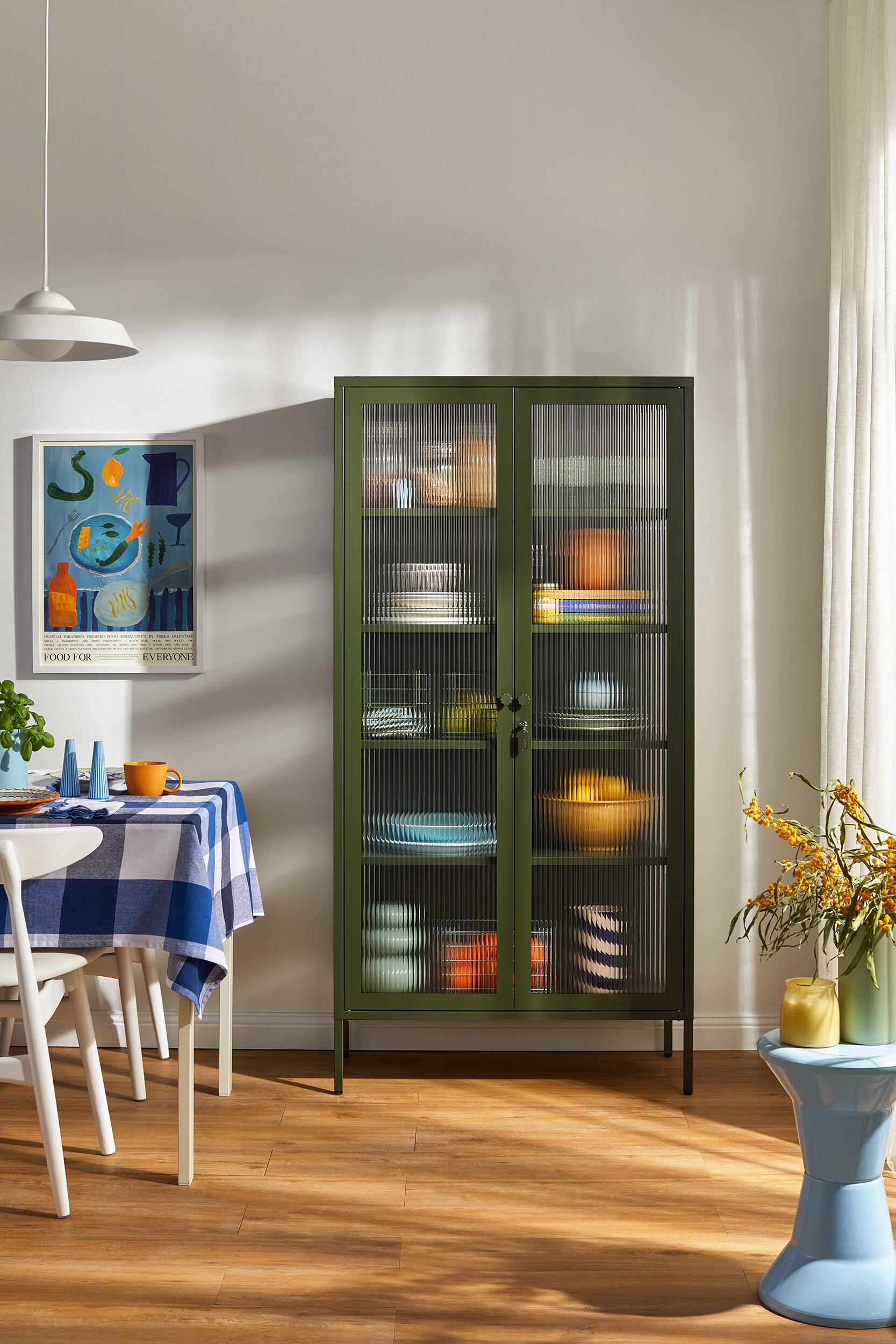 The Collector cabinet in Olive green featuring fluted glass panels and powder-coated steel frame.