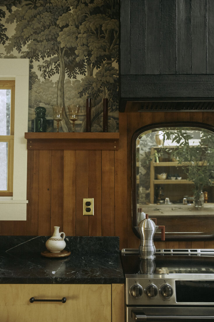 A range hood covered in shou sugi ban charred wood with a dark, textured finish.
