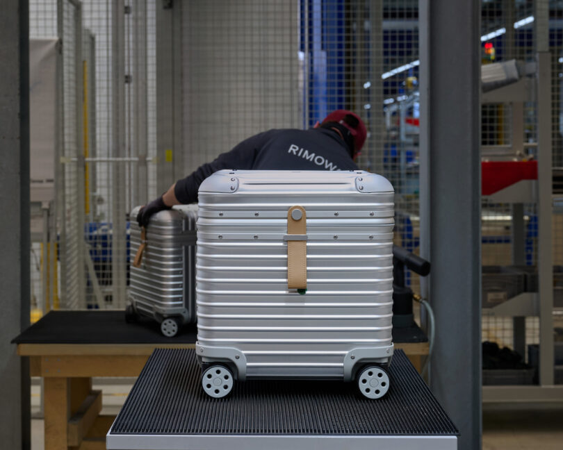 A technician in a factory setting assembles silver grooved aluminum shells for the collection.